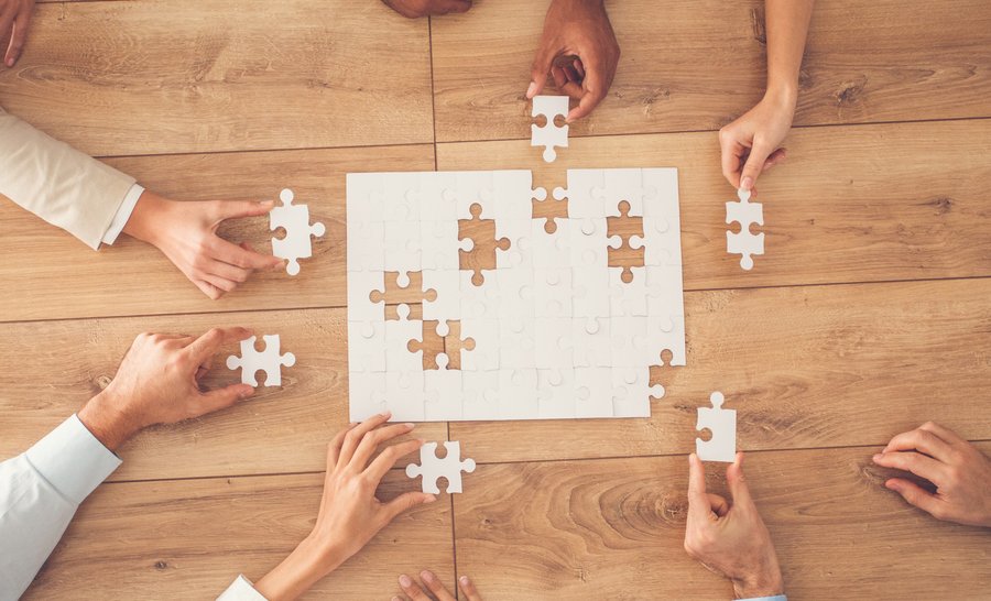 Tisch mit Puzzleteilen stellt bildlich die Mediation für Privatkunden dar.